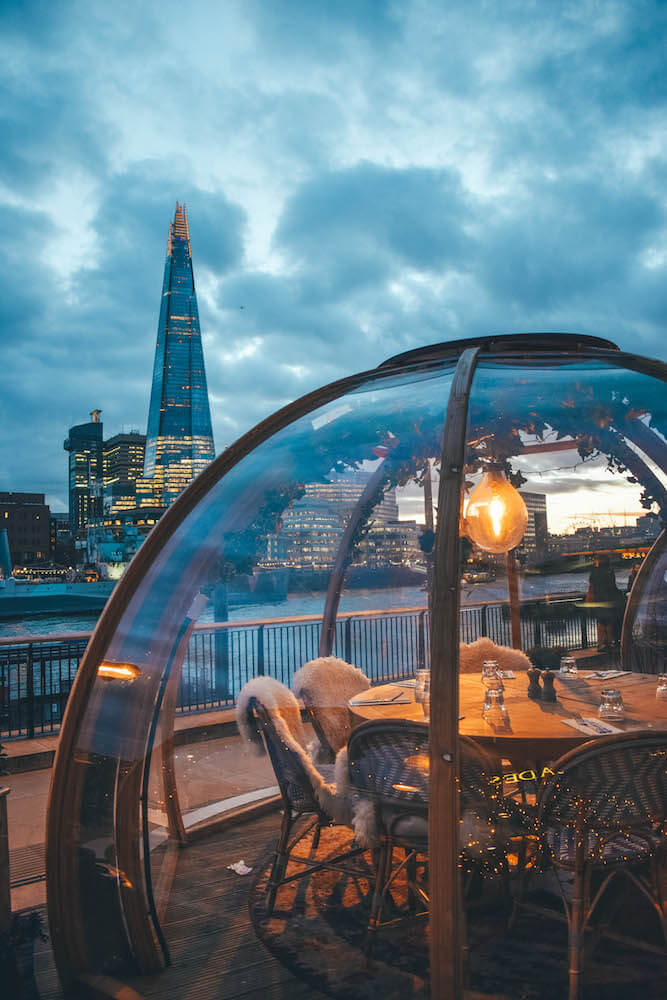 One of the glass igloos at Coppa Club at blue hour, with the Shard in the back